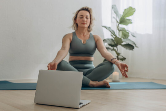 A 50-year-old woman does yoga at home