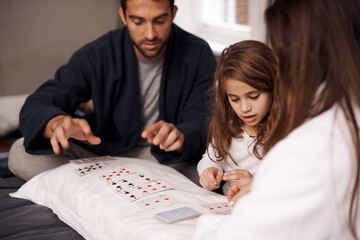 Mom, father and girl with playing cards for competition with bonding, learning and relax with...