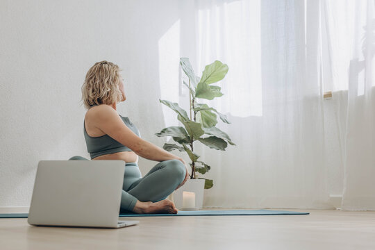 A 50-year-old woman does yoga at home