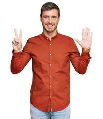 Naklejka premium Handsome caucasian man wearing casual clothes showing and pointing up with fingers number seven while smiling confident and happy.