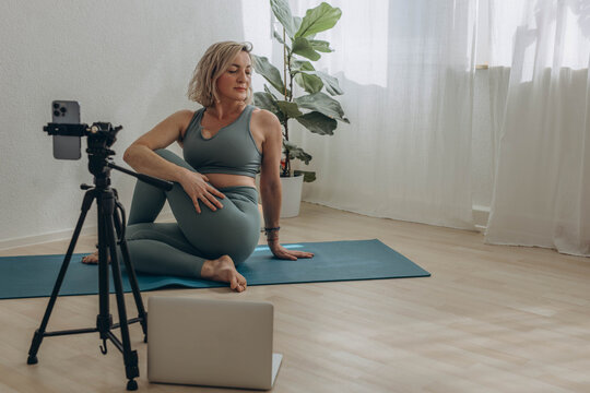 A 50-year-old woman doing online yoga at home