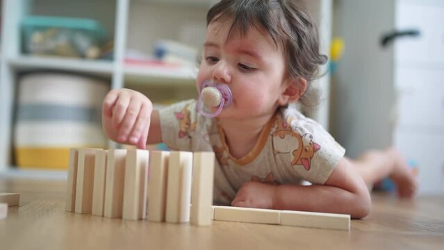 baby plays with toys with wooden sticks. happy family kid dream concept. baby girl plays indoors toys with wooden sticks, develops fine motor skills. lifestyle child playing with