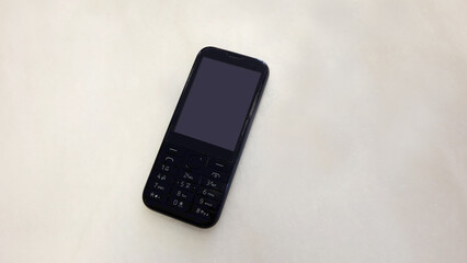 An old fashioned cellular phone, with a blank screen. 