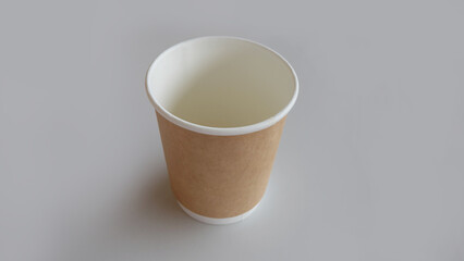 A clean and new brown disposable cup, placed on a gray surface.