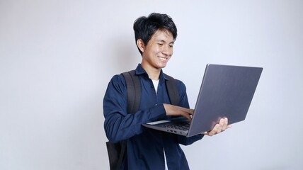 Young handsome Asian man is happy holding a laptop