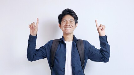 Young handsome Asian man is happy pointing upwards