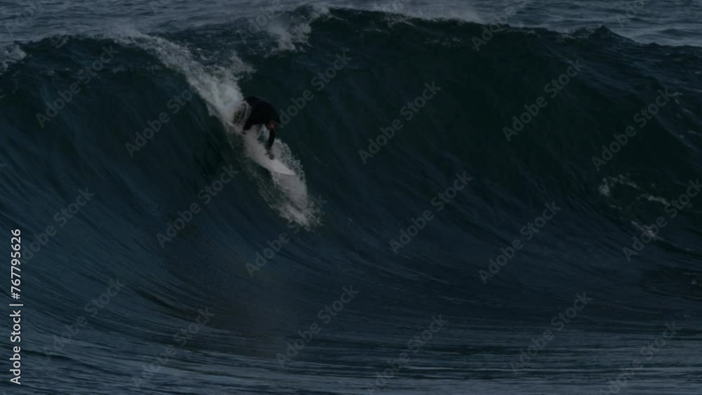 Poster surfer paddles quickly to pop up and drop in on heavy face of wave wiping out in slow motion going o