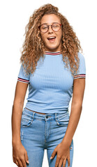 Beautiful caucasian teenager girl wearing casual clothes and glasses winking looking at the camera...
