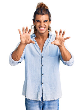 Young hispanic man wearing summer style smiling funny doing claw gesture as cat, aggressive and sexy expression