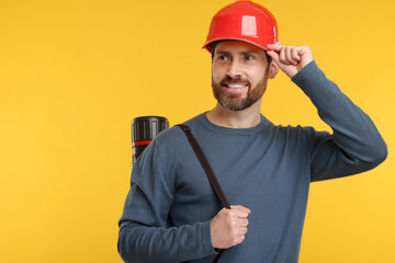 Architect in hard hat with drawing tube on orange background, space for text