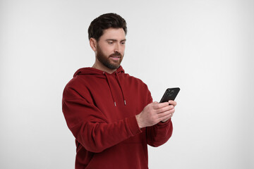 Handsome man with smartphone on white background