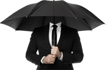 A businessman in a suit holds a black umbrella for protection from the rain