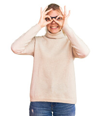 Fototapeta premium Young beautiful blonde woman wearing turtleneck sweater and glasses doing ok gesture like binoculars sticking tongue out, eyes looking through fingers. crazy expression.