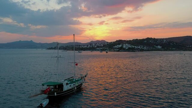 Panoramic aerial view from drone of Bodrum harbour with boats and yachts. Beautiful sunset, golden hour. Aegean sea, Bitez bay, Turkey