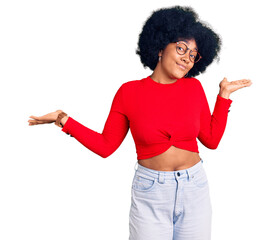 Young african american girl wearing casual clothes and glasses clueless and confused expression...