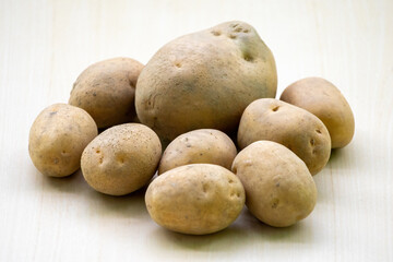 Fresh raw potatoes on a wooden background. In the Bengali language, it is called Aloo or Alu.