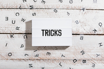 Tricks, word written in light box on table