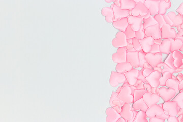 Pink textile hearts confetti on a blue background. Copy space.