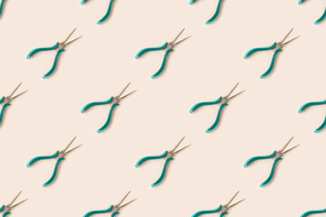 Repetitive pattern made of needle-nose pliers on a beige background.