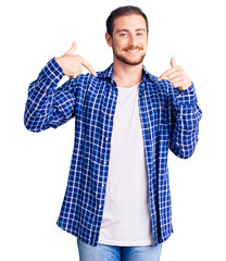 Young handsome caucasian man wearing casual clothes looking confident with smile on face, pointing oneself with fingers proud and happy.