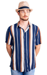 Young handsome caucasian man wearing summer hat smiling looking to the side and staring away thinking.