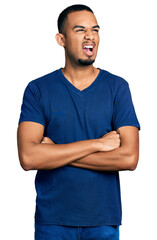 Fototapeta premium Young african american man with arms crossed gesture angry and mad screaming frustrated and furious, shouting with anger. rage and aggressive concept.
