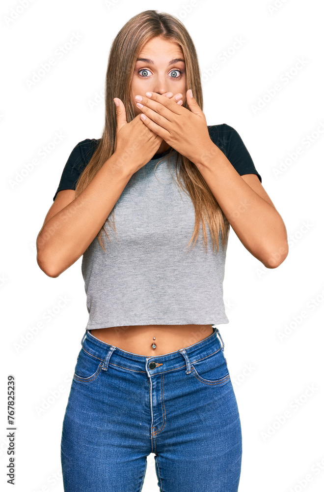 Wall mural Young blonde woman wearing casual clothes shocked covering mouth with hands for mistake. secret concept.