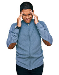 Young handsome hispanic man wearing casual sweatshirt with hand on head, headache because stress....