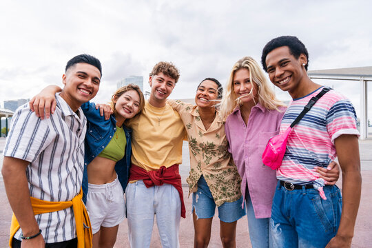 Group photo of happy young friends with colorful clothing smiling at camera