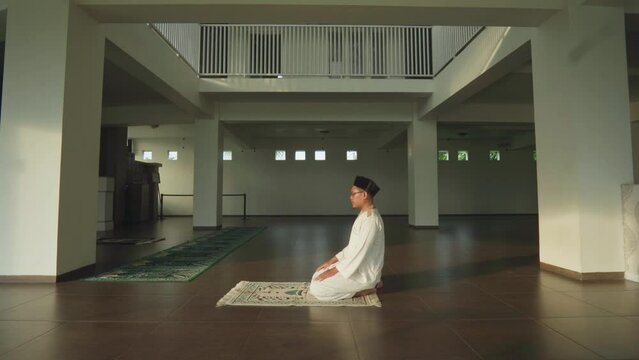 Asian moslem praying in mosque. islamic religion. During Ramadan he often prays in the mosque, worships, reads the Koran, makes dhikr, and prays to Allah.