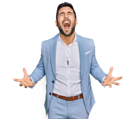 Gardinen Young hispanic man wearing business jacket crazy and mad shouting and yelling with aggressive expression and arms raised. frustration concept. © Krakenimages.com