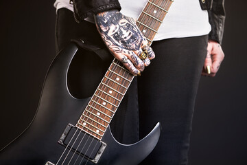 Metal, woman and guitar on black background for punk culture or grunge, edgy and goth fashion with...
