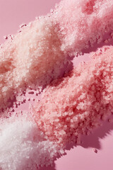 close-up swatches of bath salt or sugar rejuvenating body scrub  in natural shades of texture on a pastel pink background with a play of light and shadow