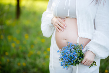 Pregnant Woman Belly. Pregnancy concept. Close-up of a Pregnant Woman holding Mom Expecting Baby....