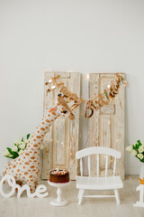 Decor for children in honor of the first birthday. Giraffe toy. A small chair. Children room