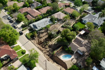 Fototapeta premium Aerial view of a suburban neighborhood with a large pool in the center surrounded by houses and greenery.