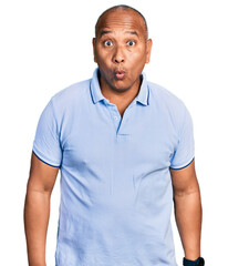 Hispanic middle age man wearing casual t shirt afraid and shocked with surprise expression, fear and excited face.