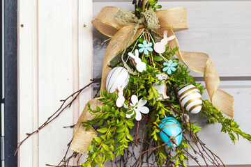 An open door and Easter decorations on wooden wall near the door. Happy Easter.