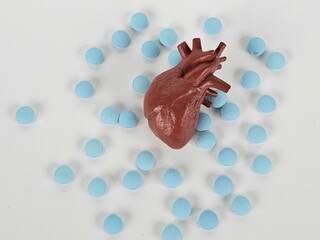 Red heart with pills. Medicines for the heart and treatment of cardiovascular disease concept