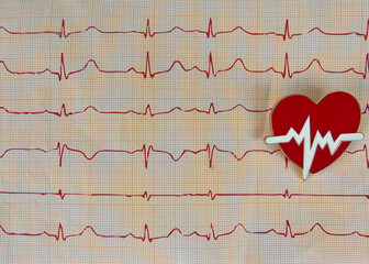 Cardiogram chart with medical and small red heart on table