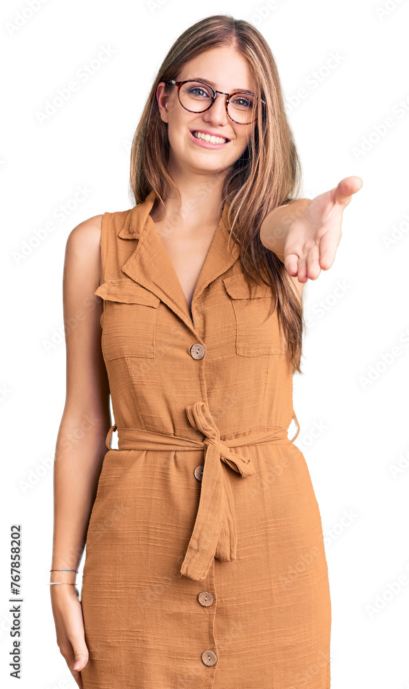 Wall mural Young beautiful blonde woman wearing casual clothes and glasses smiling cheerful offering palm hand giving assistance and acceptance.