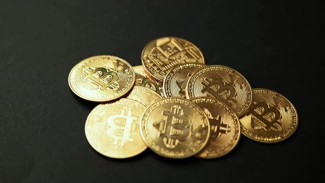A pile of bitcoins golden coins on a black background, camera rotation view. Bullish BTC, cryptocurrency, 2p2 exchange and blockchain concept
