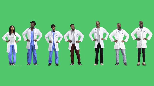 A group of doctors, full-length, on a green background, hands on the belt