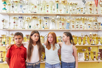 Students standing in front of trophies on shelf