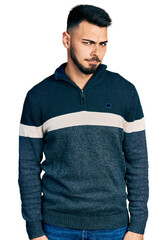 Fototapeta premium Young hispanic man with beard wearing casual winter sweater skeptic and nervous, frowning upset because of problem. negative person.