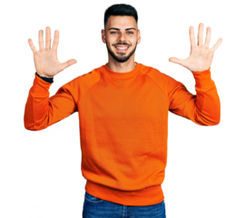 Young hispanic man with beard wearing casual orange sweater showing and pointing up with fingers number ten while smiling confident and happy.
