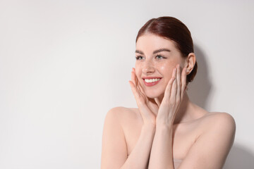 Portrait of smiling woman on light background. Space for text