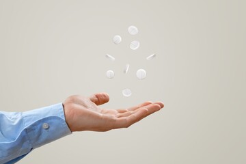 Human hand holding a pill on background