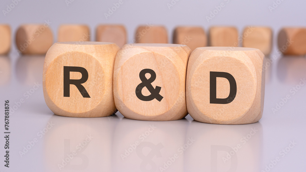 Poster the image depicts three wooden blocks with the letters 'r and d' in focus, reflecting on the table s