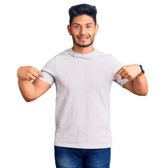 Handsome latin american young man wearing casual tshirt looking confident with smile on face, pointing oneself with fingers proud and happy.